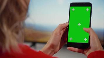 kvinna som använder smartphone med grön skärm, gör svepande, rullande gester. video