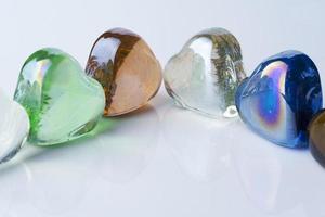 Many glass hearts of different colors. photo