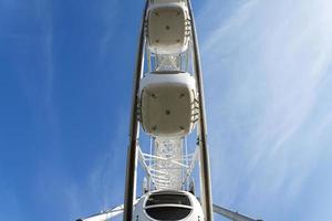 Big Ferris Wheel on clear blue sky background, close up photo