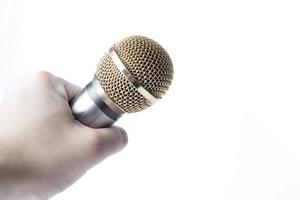 A man's hand holds a microphone on a white background. photo