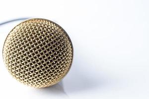 micrófono sobre un fondo blanco con una boquilla chapada en oro. foto
