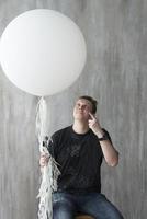 un hombre sosteniendo una pelota inflable sobre un fondo gris. foto