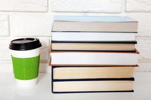 Education literature. Cup of coffee and books on the table in a class. Top view and copy space. Selective focus photo