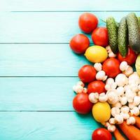 Background of colorful vegetables. Blue wooden background. Top view. Mock up. Copy space. Tomato, lemon, cucumber, cabbage. photo