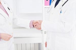 two doctors shake hands at the clinic. Medical insurance. Healthcare concept. Copy space photo