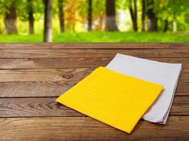 yellow grey napkins on wooden table on blurred park background photo