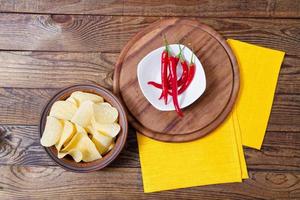 papas fritas, mantel amarillo, pimiento picante y pizzería en la mesa, fondo de comida, vacío, vista superior foto