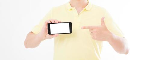 man in t-shirt shirt holding and pointing on blank screen mobile phone isolated on white background. Arm hold smartphone, copy space photo