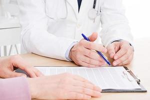 Doctor and patient are discussing something, just hands at the table, medical insurance. photo