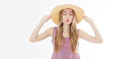 hermosa chica amigable en sombrero de verano enviando un beso con los ojos cerrados aislado sobre fondo blanco. foto