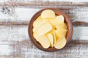 chips in a plate top view, wooden table,food photo