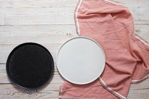 black and white empty plate mock up top view on wooden table, table cloth napkin top view photo