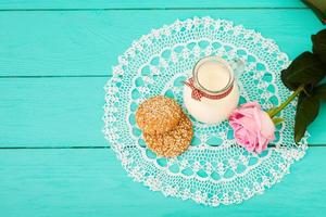 Lunch and pink rose on blue wooden background and lace napkin. Top view and copy space. Selective focus