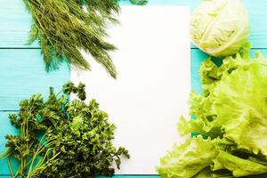 Parsley and recipe paper on blue wooden kitchen table. Top view photo