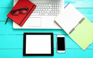 Electronic devices with copy space and keyboard on blue wooden background. Working accessories. Top view photo