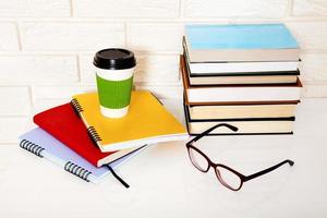 Workspace and education accessories on the table. Cup of coffee, books, glasses, notebooks, headphones. Stem education photo