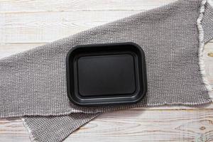 vista superior de la maqueta de la bandeja en la mesa con mantel de servilleta de lino gris foto