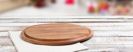 empty pizza board on empty wooden table with tablecloth,napkin - top view photo