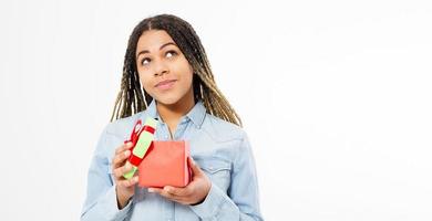 Portrait of an excited cute teen black woman holding opened present box isolated over white background photo