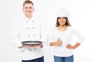 Two happy smile chefs holding an empty tray and show like sign isolated on white. White and afro american cookers in uniform.