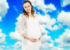 mujer embarazada con ropa informal aislada en un fondo borroso del cielo, mujer embarazada con ropa informal aislada en un fondo azul, bella dama embarazada, esperando un bebé foto