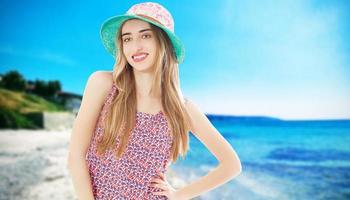 Mujer joven y hermosa con sombrero en un día soleado en el mar y la playa foto