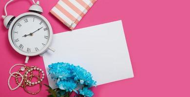 espacio de trabajo con espacio de copia. accesorios de tablero de humor de moda de mujer sobre fondo rosa. maqueta de reloj y flores. vista superior y escritorio adolescente. maqueta de estilo y plantilla de verano. bandera foto