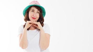 Anti wrinkle aging summer face skin protection. Middle age woman in beach hat and makeup in white template t shirt isolated. Holiday and vacation concept. Copy space background. Banner photo
