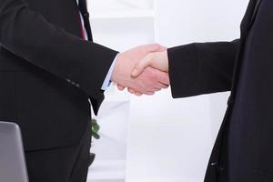 Stylish Successful businessmen handshaking after profitable deal at office background. Image of businessmans handshake in suits . Copy space and selective focus. Business partnership concept. photo