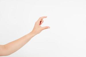 female hand measuring invisible items, woman's palm making gesture while showing small amount of something on white isolated background, side view, close-up, cutout, copy space photo