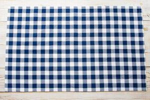 Blue checkered tablecloth on table top view photo