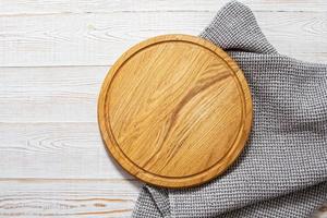 Pizza board with napkin on table topview. Empty pizza board top view mock up photo