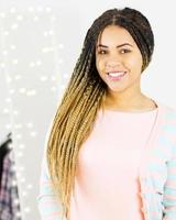 happy black girl in pink dress on blurry bokeh background on mirror, afro american woman