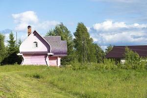 Rural, pink wooden house in the village.