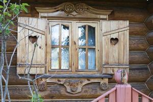 Wooden window with shutters in a wooden farmhouse. photo