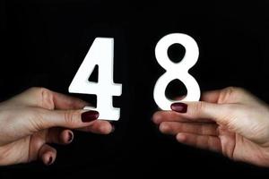 To female hands the number forty-eight. photo