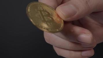 Gold Bitcoin giving and receiving by hand. Represent cryptocurrency transaction video