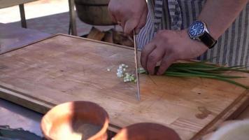cocinero corta cebollas verdes