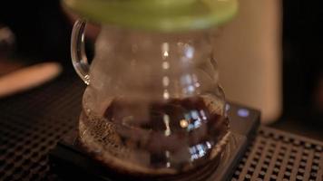 slow-motion shot of barista who making a hot of coffee by filter drip pouring water process, homemade coffee in morning at home or cafe, vintage hand brewing water over roasted coffee beans