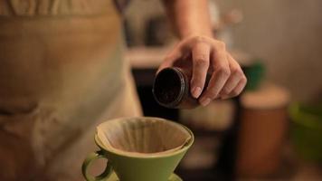 Zeitlupenaufnahme von Barista, der einen heißen Kaffee durch Filtertropfwasserprozess zubereitet, hausgemachter Kaffee am Morgen zu Hause oder im Café, Vintage-Handbrühwasser über gerösteten Kaffeebohnen video