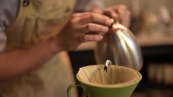 Slow-motion-bild av barista som gör en varm kaffe med filterdroppande vattenprocess, hemlagat kaffe på morgonen hemma eller café, vintage handbryggande vatten över rostade kaffebönor video