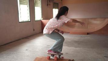 joven asiática jugando patinaje, patineta o patinadora de surf en un estilo de vida de entrenamiento saludable en tiempo de vacaciones, moda deportiva callejera en la vida urbana de la ciudad, cámara lenta video