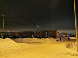 fuegos artificiales de año nuevo en el pueblo de cabañas en una noche de invierno foto