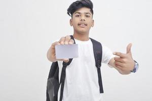 estudiante universitario indio que muestra la tarjeta sobre fondo blanco.
