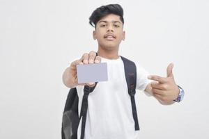 estudiante universitario indio que muestra la tarjeta sobre fondo blanco. foto