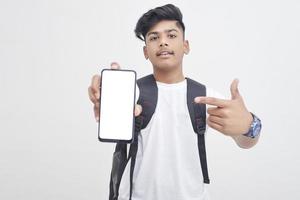 Indian college student showing mobile screen on white background. photo