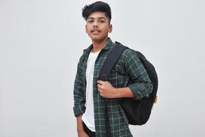 Handsome Indian collage boy standing on white background. photo