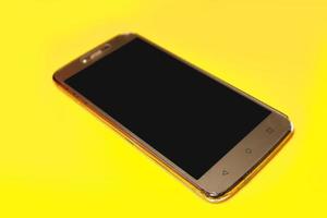 Smart phone on yellow background. photo