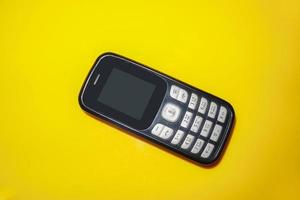 vintage mobile phone with copyspace on yellow background. photo