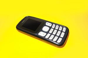 vintage mobile phone with copyspace on yellow background. photo